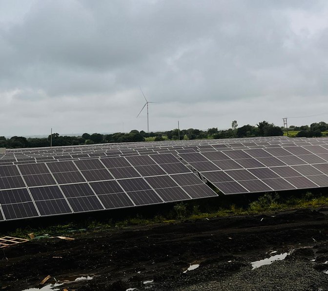 Rows of solar modules under a cloudy sky